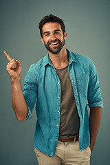 Image showing Point, smile and portrait of happy man in studio on gray background for announcement, news and information. Fashion, mockup space and male person with hand sign for promotion, choice and branding