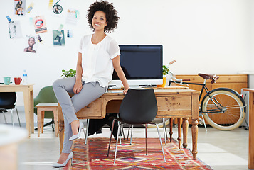 Image showing Entrepreneur, office and portrait of woman Designer or small business worker happy for company growth sitting on desk. Creative, computer and employee or manager smile in a fashion agency or startup