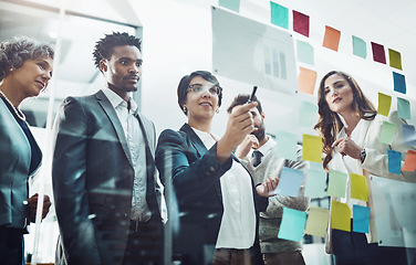 Image showing Business people, team and glass board with writing, brainstorming and talking for solution, idea or goal. Group, strategy and focus with concentration for proposal, project and teamwork in workplace