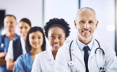 Image showing Smile, team and portrait of senior doctor with nurses in hospital, leadership and teamwork in healthcare. Health, diversity and confident doctors in group and happy medical employees in row together.