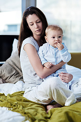 Image showing Baby, mother and sad with postpartum on bed at family house and problem with stress or being tired. Mom, newborn and depression with mental health at home with insomnia about child development.