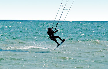 Image showing Silhouette of a kitesurfer on waves of a sea