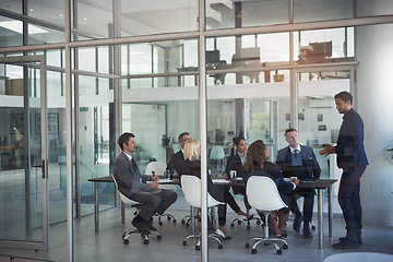 Image showing Executive, meeting and group in office room for corporate planning, strategy or business training. Management, people at table and businessman or speaker, mentor and professional advice to company