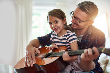 Image showing Father, guitar and teaching a girl in portrait with happiness at home for fun or love or bonding. Music, acoustic and instrument with parent and daughter for learning or care with music together.