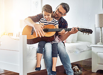 Image showing Bedroom, teaching and guitar with father, girl for fun with music at the house for bonding. Instrument, acoustic and learning with parent, child in room with happiness or love or creativity at house.