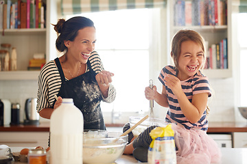 Image showing Mother, play or child baking in kitchen as a happy family with an excited girl learning cookies recipe. Cake, daughter laughing or funny mom helping or teaching kid to bake with smile for development