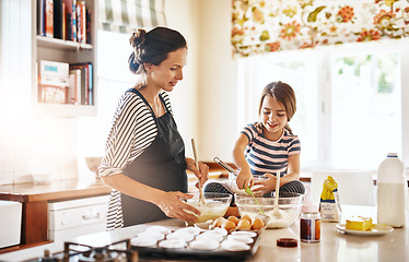 Image showing Mom cooking or girl child baking in kitchen as a family with a young kid learning cookies recipe at home. Cake pastry, baker or happy mother helping or teaching daughter to bake for skill development