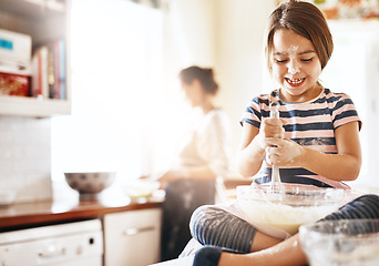 Image showing Messy, happy and child baking in the kitchen with parent for bonding, food and dessert. Funny young girl mixing flour in a bowl with chaos, energy or cooking with happiness while playing for learning
