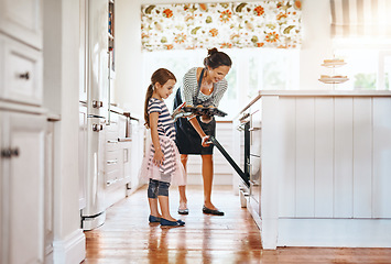Image showing Food, mother with a girl baking and in the kitchen of their home together with a lens flare. Happy family or bonding time, bake or cook and woman with her daughter prepare meal for lunch at oven