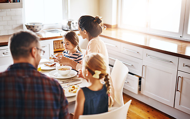 Image showing Family, morning and breakfast by table in kitchen for meal, eating or bonding time together at home. Mother, father and children with healthy food to start the day for nutrition or cereal in house