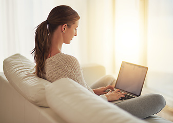 Image showing Laptop, remote work and woman typing on sofa in home living room. Computer, freelancer and professional on couch in lounge writing blog, copywriting or working on project, email and internet research