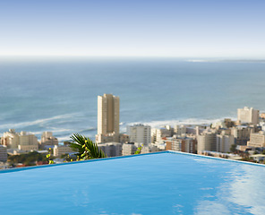 Image showing Travel, vacation and pool in city with ocean and hotel view in Cape Town with nobody, buildings and urban beach property. Cityscape, sea and blue sky at luxury accommodation for summer holiday trip.