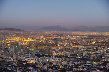 Image showing Night, cityscape and urban buildings, architecture or infrastructure for development, expansion and property. Skyline, cbd and mountains with city skyscraper, commercial road or space in Cape Town