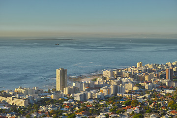 Image showing Cityscape, urban buildings and architecture by ocean, infrastructure and property development in metro. Skyline, cbd and seaside with city skyscraper, Cape Town and mockup space in summer sunshine