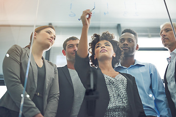 Image showing Woman, writing and glass with business people in teamwork for strategy, planning and collaboration in office. Female leader, pen and brainstorming with group, ideas and notes for goal with diversity