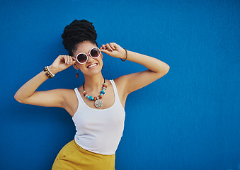 Image showing Fashion, sunglasses and portrait of woman on blue background, wall and summer streetwear, trendy clothes or shades mockup. Girl, happy and excited model with cool style, vision and urban mock up