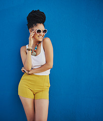 Image showing Sunglasses, fashion and portrait of woman on blue background, wall and summer streetwear, trendy clothes or shades mockup. Girl, happy and excited model with cool style, vision and urban mock up