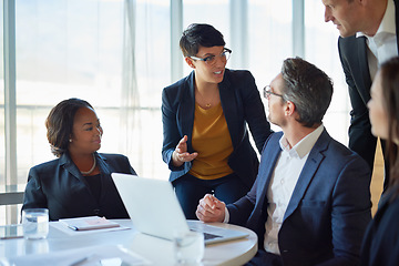 Image showing Diversity, colleagues with laptop and at desk in a boardroom of their modern workplace. Collaboration or teamwork, support or brainstorming for help and coworkers working together on a project