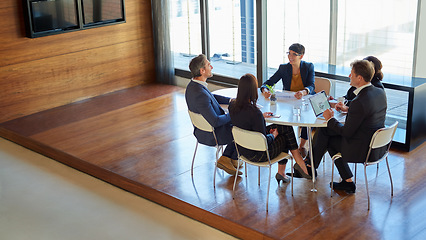 Image showing Professional, group and meeting for a discussion or collaboration at a company with a plan. Teamwork, conversation and strategy at a table for a project or partnership with tech at the office.