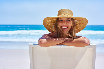 Image showing Portrait, beach and woman with a smile, holiday and summer getaway with tourism, break or travelling. Face, female person or girl on a chair, seaside vacation or travel with a hat or relax with waves