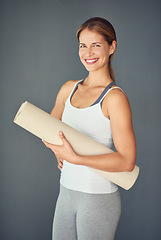 Image showing Happy woman, portrait smile and yoga mat for exercise, healthy wellness or workout against a grey studio background. Excited female person or yogi smiling for mindfulness, zen fitness or body health