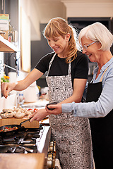 Image showing Cooking, grandmother and woman together in kitchen or teach recipe, prepare dinner or lunch with family. Senior mother, girl and happy in apron or home, food and cook with healthy vegetables