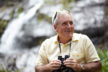 Image showing Binoculars, happy man and forest or mountains thinking of journey, outdoor adventure and carbon footprint tourism. Senior person with gear for birdwatching experience or search nature by waterfall