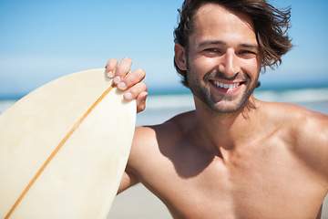 Image showing Portrait, surfboard and a man in the sea at the beach for surfing while on summer holiday or vacation. Face, smile and sports with a happy young male surfer shirtless outdoor by the ocean for a surf