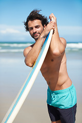 Image showing Portrait, surf and a man in the ocean at the beach for surfing while on summer holiday or vacation. Surfboard, body and windy with a young male surfer shirtless outdoor by the sea for a sports hobby