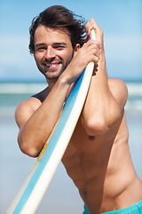 Image showing Portrait, surf and a man in the ocean at the beach with his surfboard while on summer vacation or holiday. Face, smile and body with a happy young male surfer shirtless outdoor by the sea for surfing