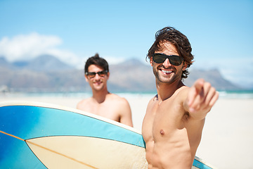 Image showing Beach, pointing and man surfing friends outdoor together for summer vacation or holiday trip overseas. Surf, sea or travel with a young male surfer in sunglasses and friend bonding on an ocean coast