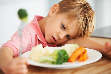 Image showing Sad, healthy and a child with vegetables for dinner, unhappy and problem with food. Frustrated, hungry and a little boy eating broccoli and carrots, disappointed with lunch and nutrition for youth