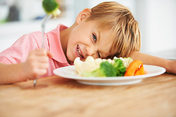 Image showing Food, health and child eating vegetables for a healthy, growth and wellness diet at his home. Nutrition, dinner and boy kid laying on a dining table with produce lunch, snack or meal at his house.