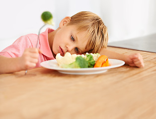 Image showing Sad, hungry and a child with vegetables for dinner, unhappy and problem with food. Frustrated, diet and a little boy eating broccoli and carrots, disappointed with lunch and nutrition for youth