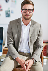 Image showing Portrait, glasses and focus with a business man in the office for corporate or professional work. Face, eyewear and leadership with a young male manager sitting in a workplace on a blurred background