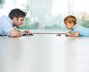 Image showing Playing, happy and a father and child with cars for bonding, quality time and happiness. Smile, family and a dad with a boy kid and toys for a race or competition on the floor of a house together