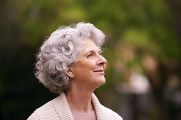 Image showing Happy senior woman, relax and thinking in nature for hope, joy or retirement in the outdoors. Face of thoughtful elderly female with smile in happiness, wonder or dream for natural life or vitality