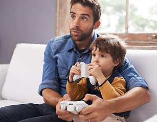 Image showing Gaming, father and son on a sofa, playing and loving at home, quality time and bonding. Family, dad or male child on a couch, controller or playful with fun, relax and connection with joy or cheerful