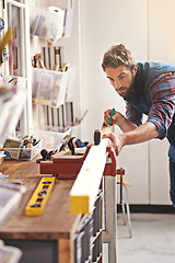 Image showing Man, workshop and tape measure for construction, home development and building renovation. Carpenter, maintenance employee and male repairman worker on a contractor job of builder working in house