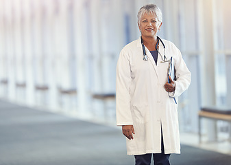 Image showing Portrait, healthcare and documents with a senior doctor standing in a hospital corridor for insurance or treatment. Medical, trust and paperwork with a woman medicine professional in a health clinic