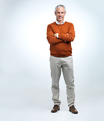 Image showing Mature man, portrait and arms crossed in a studio with modern style, fashion and smile. Happy, senior and old male person with white background with confidence and casual jersey alone with joy