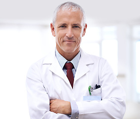 Image showing Healthcare, portrait of man doctor with arms crossed and in a hospital. Medical health wellness, specialist or stand and confident professional mature male surgeon or nurse at clinic for support