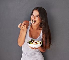 Image showing Woman is eating a salad, healthy food and nutrition, portrait and vegetables isolated on wall background. Happy, vegan and health with wellness, diet and female model to lose weight with mockup space