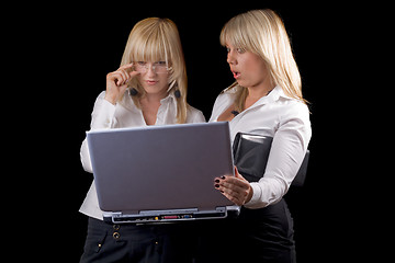 Image showing Two young businesswomen with laptop. Isolated on black