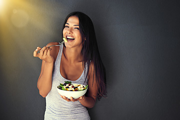 Image showing Happy woman is eating a salad, healthy food and nutrition, portrait and vegetables isolated on wall background. Organic, vegan and health with diet, female model to lose weight with mockup space