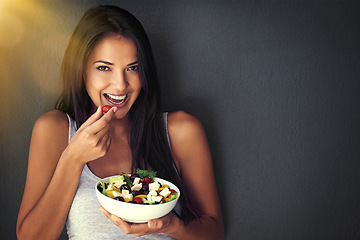 Image showing Woman is eating a tomato from salad, portrait and healthy food with nutrition and vegetables on wall background. Happy, vegan and health, female model on diet to lose weight and mockup space