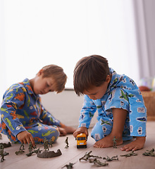 Image showing Young boys, playing and toys together in pajamas for fun with miniature action figures, toy car or games. Brothers, sibling children and family bonding in playroom at home for learning or development