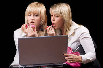 Image showing Two blondes do makeup in front of the laptop screen