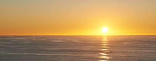 Image showing Orange sky, sunset and sea at morning on the horizon with ocean and waves landscape. Sunrise background, calm weather and summer by beach with coastline and outdoor environment with sun and mockup