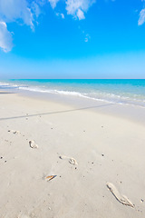 Image showing Ocean, blue sky and landscape with beach sand and travel, waves and summer vacation outdoor in Hawaii. Environment, horizon and seaside location with tropical destination and journey on island